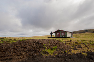 man walking towards a cabin in the countryside in iceland