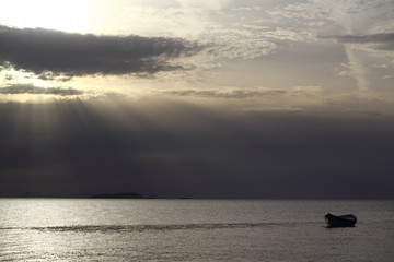 Sunset in the sea with a boat. A picture of a small boat with a beautiful sunset background.