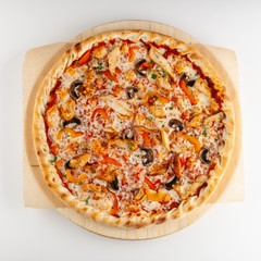 Round pizza on thin dough with grilled chicken breast, bell pepper, champignons, cheese and ricotta, isolated on white background