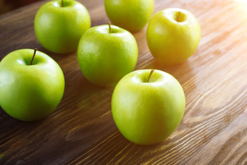 Group of green apples on brown wooden background. Close up