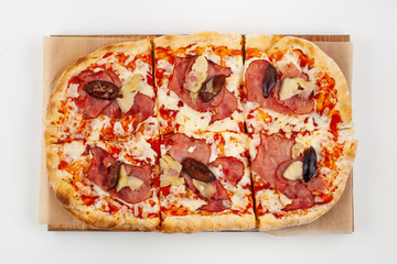 Roman square pizza with cheese, champignons, plum and pastrami, baked in coal stove and isolated on white background