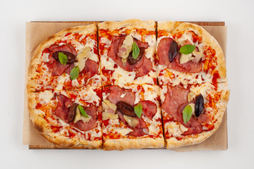 Roman square pizza with cheese, champignons, plum and pastrami, baked in coal stove and isolated on white background
