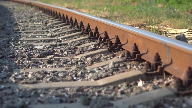 Railway rails and sleepers in summer sunny day. Close-up. Railroad track