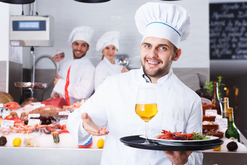 chef with dishes on serving tray welcoming