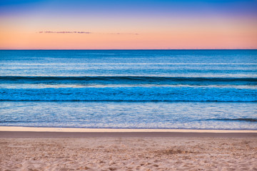 A beautiful sunset afternoon at Noosa beach overlooking the ocean and golden sky