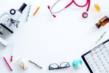 Do medical research with microscope, stethoscope, pad, pills and test tube on white background top...