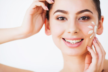Sun Tanning. Beauty Girl Applying Sun Tan Cream on her Face.