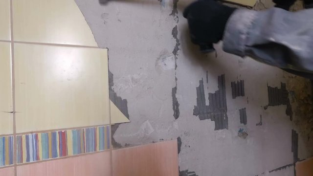 Demolition of old tiles with jackhammer. Renovation of old walls in the bathroom or kitchen