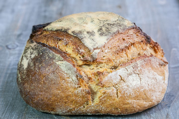 Loafs (or miche) of French sourdough, called as well as Pain de campagne, on display on a wooden table. Pain de Campagne is a typical French huge loaf of bread abiding by the traditional codes