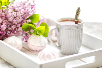The tea served in a gift box with marshmallows and a bouquet of a lilac. Close up.