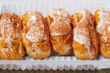 eclairs pastry in a plastic box, close-up view