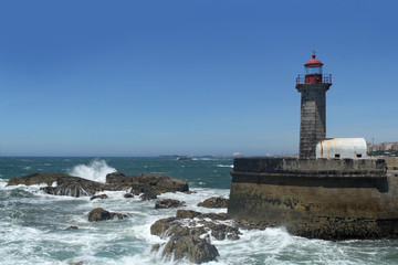Fototapeta na wymiar beautiful strict lighthouse on the shore of the blue atlantic ocean in portugal