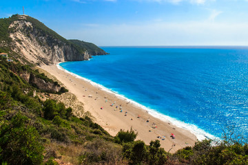 Beautiful summer scenery with blue sea and sandy beach full with tourists.