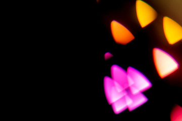 Multicolored spots on a black background. Multicolored bright big bokeh beautifully glow on a black background. copy space