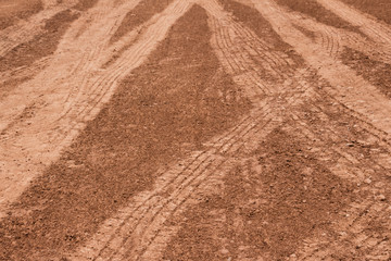 Many long wheel marks left by vehicles passing through the red earth
