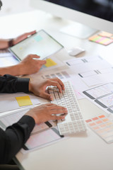 UI UX designer Team planning application prototype wireframe on tablet and paperwork layout