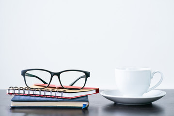 Coffee cup and eyeglasses on desk