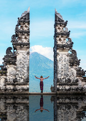 Unidentified person at the gate of Pura Penataran Lempuyang infront of Mt Agung Volcano in Bali Indonesia. - obrazy, fototapety, plakaty