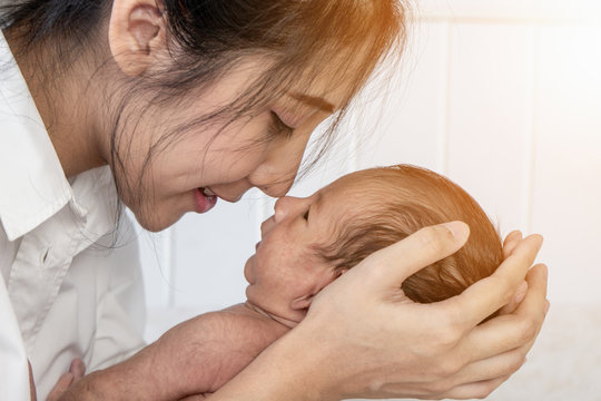 mother holding her infant baby boy on hand