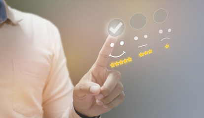 business man pressing smiley face emoticon on virtual touch screen.