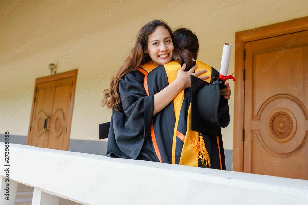 Sticker Female university graduates celebrate happily after completed and received diploma degree certificate in commencement ceremony. The women graduate express congratulations with each other.