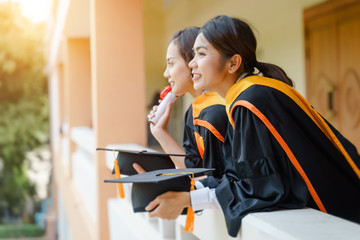 Female university graduates celebrate happily after completed and received diploma degree...