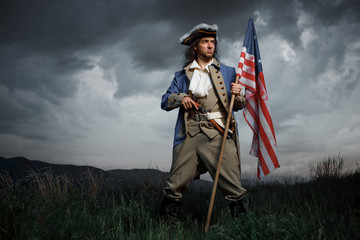 Man in United States War of Independence soldier costume with flag posing in forest. 4 july independence day of USA concept photo composition - 273970378