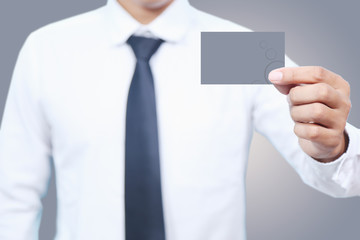 man in white shirt hold  card  on Gray  background