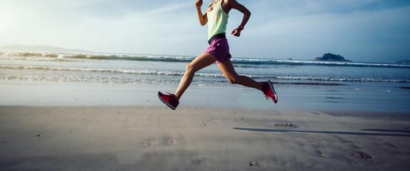 Fitness woman runner running on beach