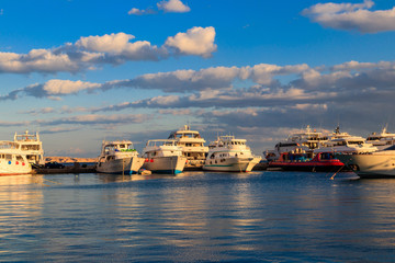 White yachts in the sea harbor of Hurghada, Egypt. Port with tourist boats on the Red Sea