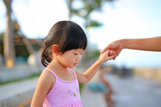 Portrait of child girl walking with mother hold one's hands at seaside, Happy family.