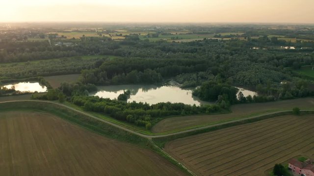 4K Aerial : Fast Cinematic spotlight shot over a natural lake in a typical italianrural landscape
