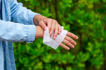 Using antibacterial wet wipes for disinfection hands in park