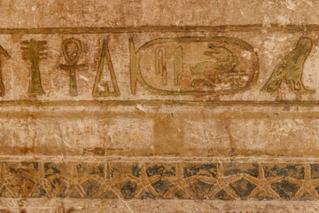 Ancient egyptian hieroglyphs carved on the stone wall
