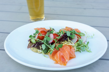 Salmon salad with mixed vegetable on white plate