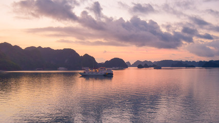 Fototapeta premium Tourist Junks in Halong Bay,Panoramic view of sunset in Halong Bay, Vietnam, Southeast Asia
