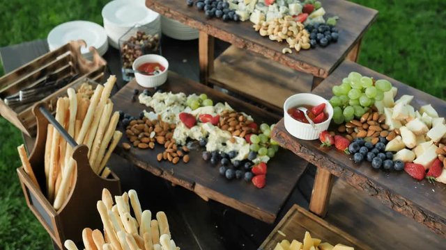 Catering service. Station with a large assorted cheese Cheddar, Gorgonzola, Brie, Gouda cheese, Parmesan, Feta, Ricotta, Maasdam, Emmental and Gruye. 4k Camera movement slow motion. Decorated with