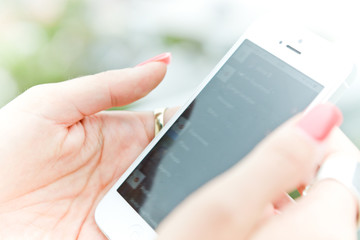 Woman scrolling her contact list on her mobile phone.