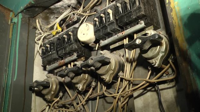 The old electric circuit control board with the old wiring. Electrical equipment. Shield in the wall of the house. wrong connection, automatic distribution, wires are tangled.