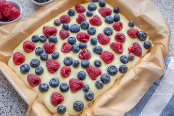 Sweet delicious crumble cake in a baking form and pieces of the cake on a table