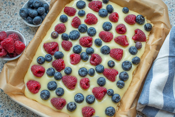 Sweet delicious crumble cake in a baking form and pieces of the cake on a table
