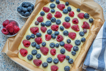 Sweet delicious crumble cake in a baking form and pieces of the cake on a table