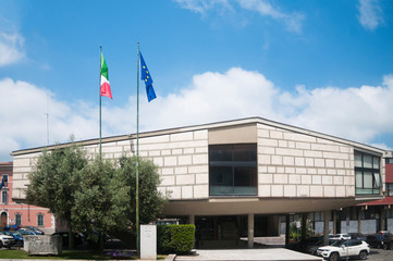 View of Carrara, Italy: the town hall building of the Tuscan city Carrara with the Italian and European flag