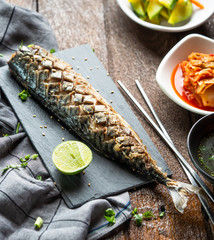 One set of saba grill serve with slide dish, kimchi, rice and seaweed soup with korean style serve menu on wood table.