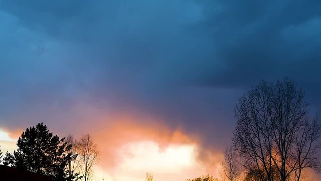 Bright sunset or sunrise on a dark sky with thunderclouds. Sunset or sunrise with dark clouds and sunlight , against the light 