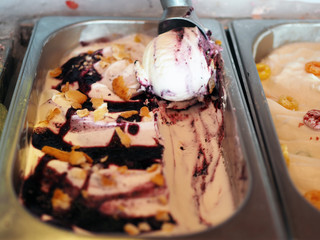 Scooping blueberry swirl with cereal Ice cream flavored from metal tray, selective focus.
