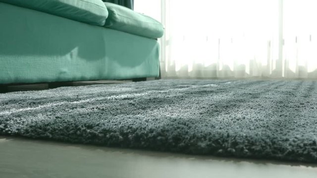 detail of soft sofa pale blue fabric close up with carpet rug under furniture and light from white curtain window