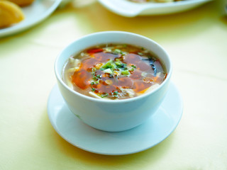 White bowl of hot and sour Sichuan style, Chinese traditional food. Selective focus.
