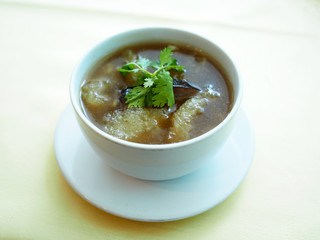 Ceramic cup of delicious Braised Fish Maw in Red Gravy soup. Selective focus. 