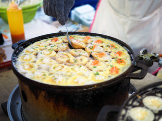 Thai Pan Fried Seafood Omelette or takoyaki in Thai style with crab stick, oyster and squid. Selective focus.